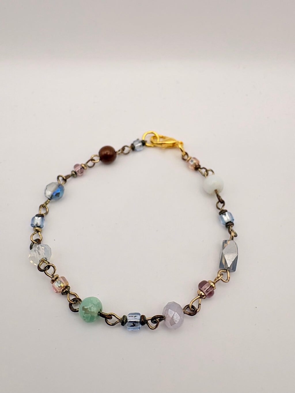 Close view of delicate chain bracelet with green bead