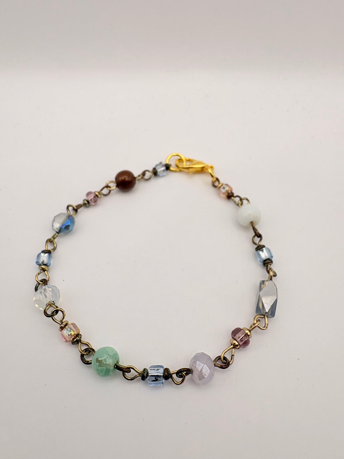Close view of delicate chain bracelet with green bead